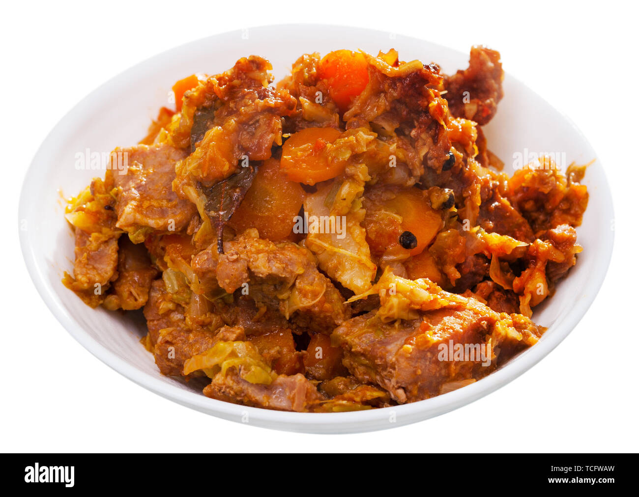 Appetitlich Kohl geschmort mit Schweinefleisch und Karotten auf weiße Platte. Auf weissem Hintergrund Stockfoto