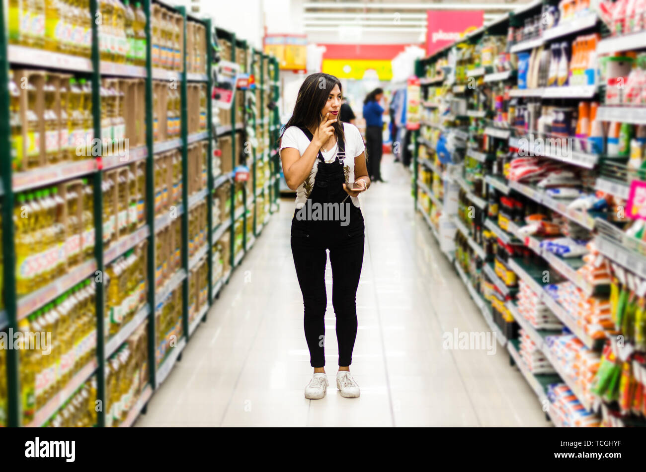 Nachdenkliche Frau, Haus einkaufen für die speisekammer im Supermarkt Stockfoto