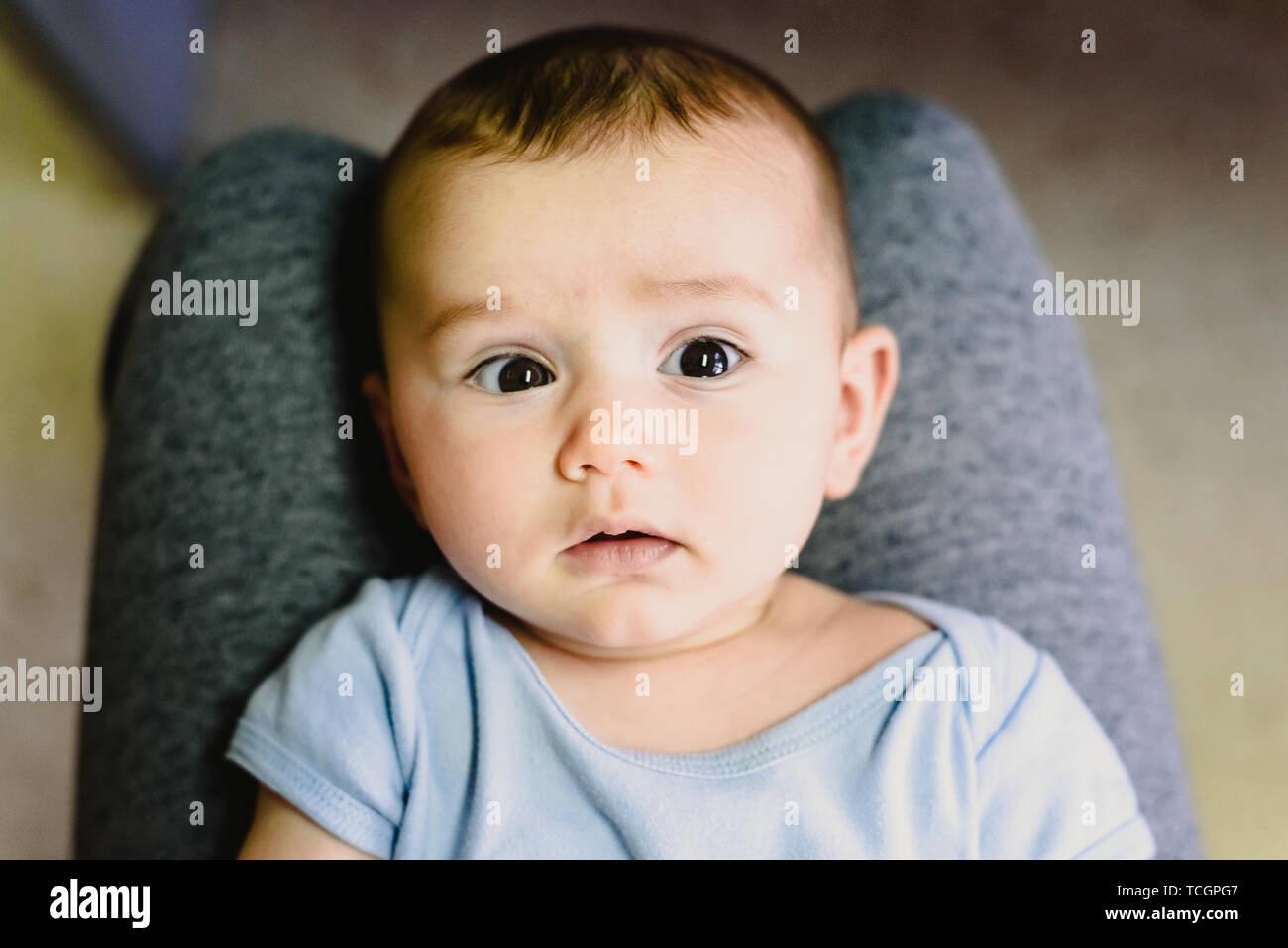 Portrait der runden Gesicht eines Babys auf die Beine seiner Mutter. Stockfoto