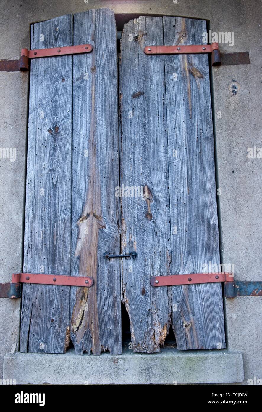 Ein altes verwittertes Holz- Shutter ist über ein Fenster geschlossen Stockfoto