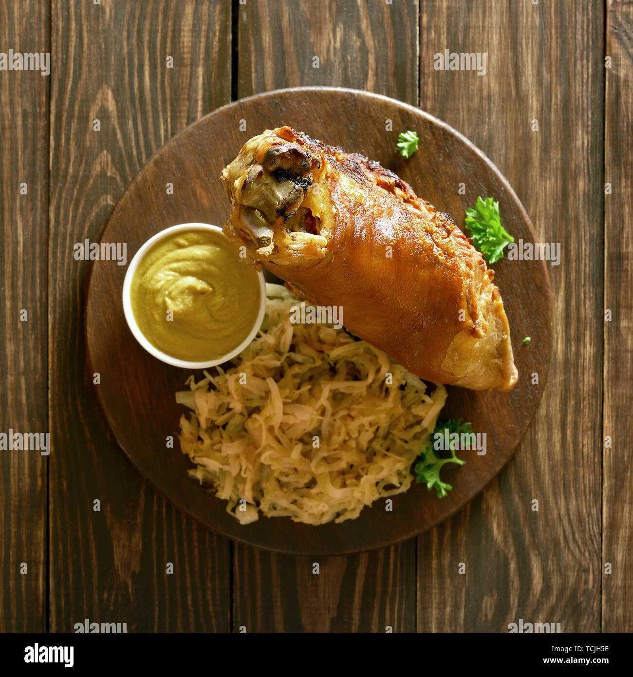 Eisbein (eisbein) mit gedünstetem Kraut (Sauerkraut) und Senf auf Holz ...