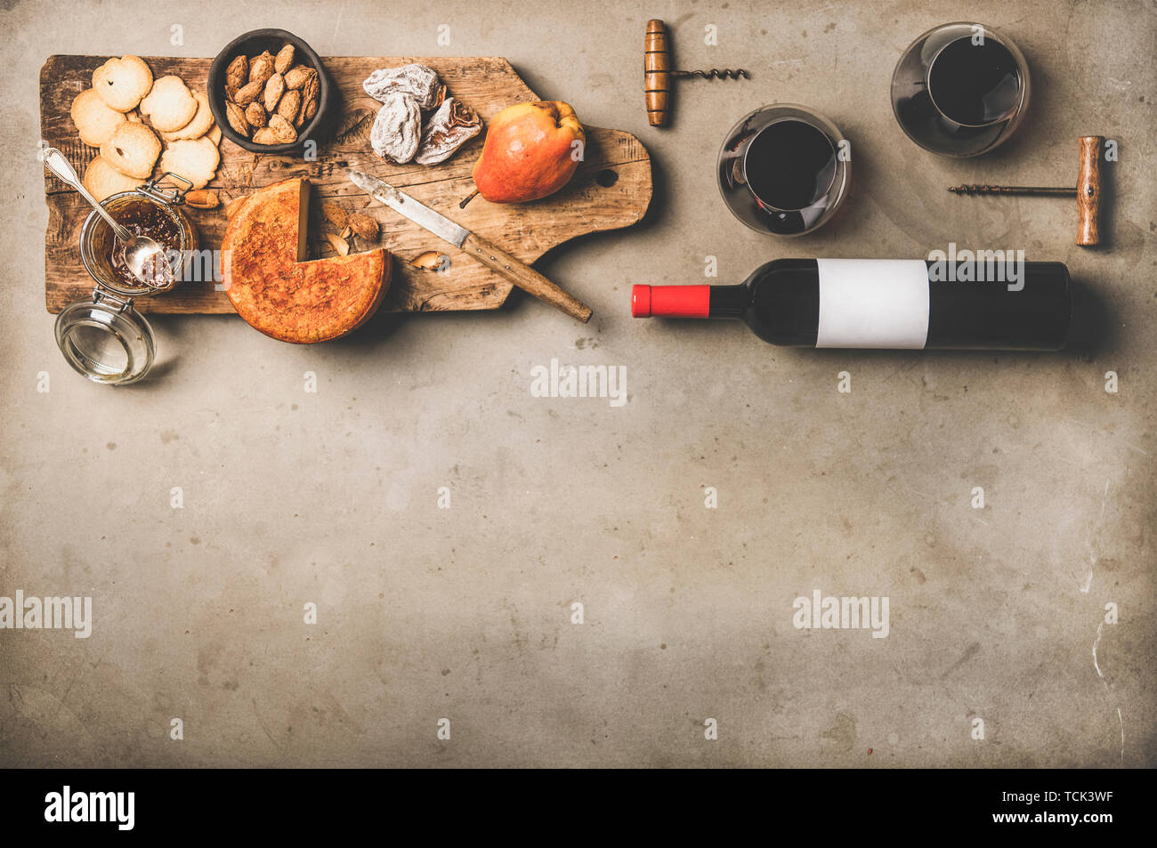 Flasche Wein, Gläser mit Wein und Aperitifs auf Holzbrett Stockfoto
