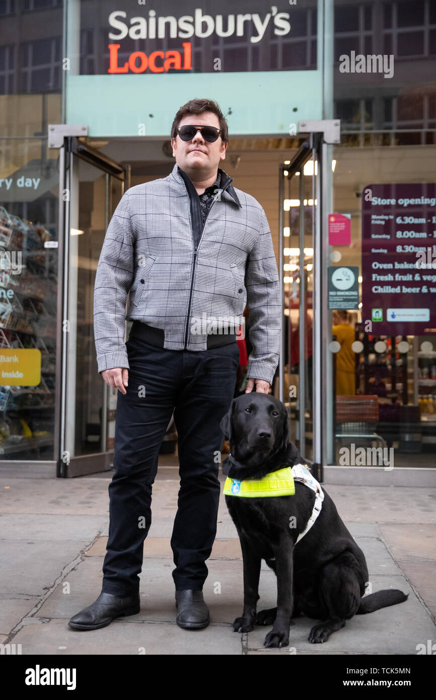Britischen Paralympic ski Meister John Dickinson-Lilley, mit seinem Blindenhund Brett, außerhalb der lokalen des Sainsbury Store auf Southampton Row in Holborn, London, wenige Minuten von der Supermarktkette Zentrale, wo er zweimal Eintrag zusammen mit seinem Hund verweigert wurde. Stockfoto