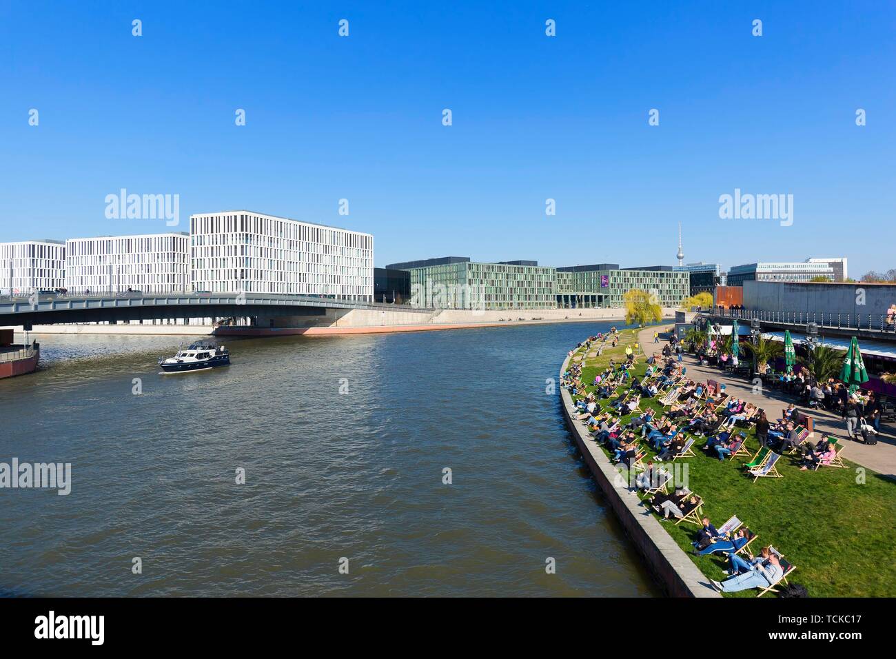 Ludwig-erhard-Ufer an der Spree mit Liegestühlen, auf der linken die Hugo Preuss Brücke mit PricewaterhouseCoopers und dem Bundesministerium für Stockfoto