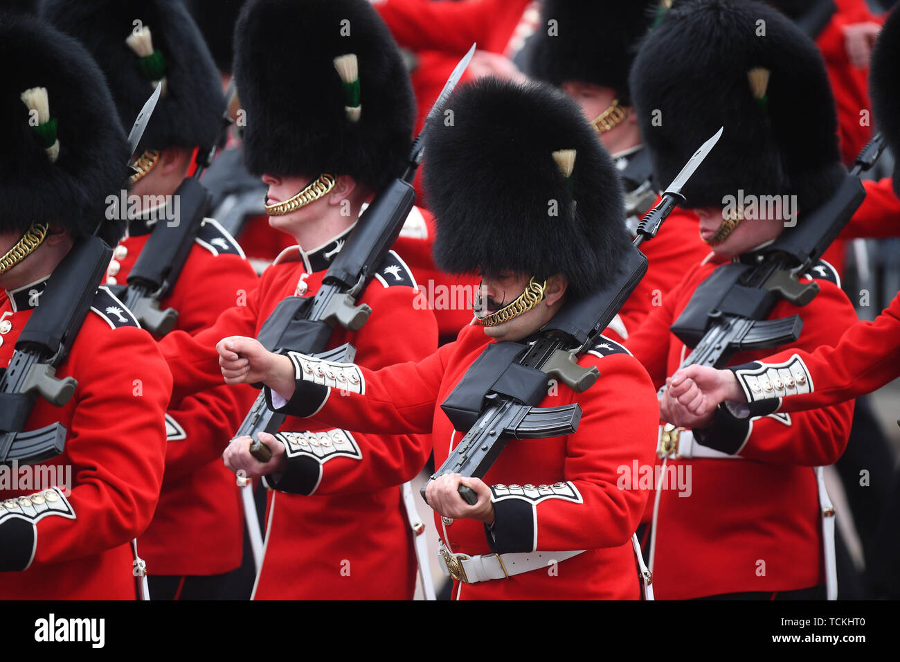 Mitglieder der Welsh Guards, ein Regiment von Haushalt Division, März bis Horse Guards Parade, London mit ihren Gewehren in der Hand, vor der die Farbe Zeremonie, als sie ihren offiziellen Geburtstag feiert. Stockfoto