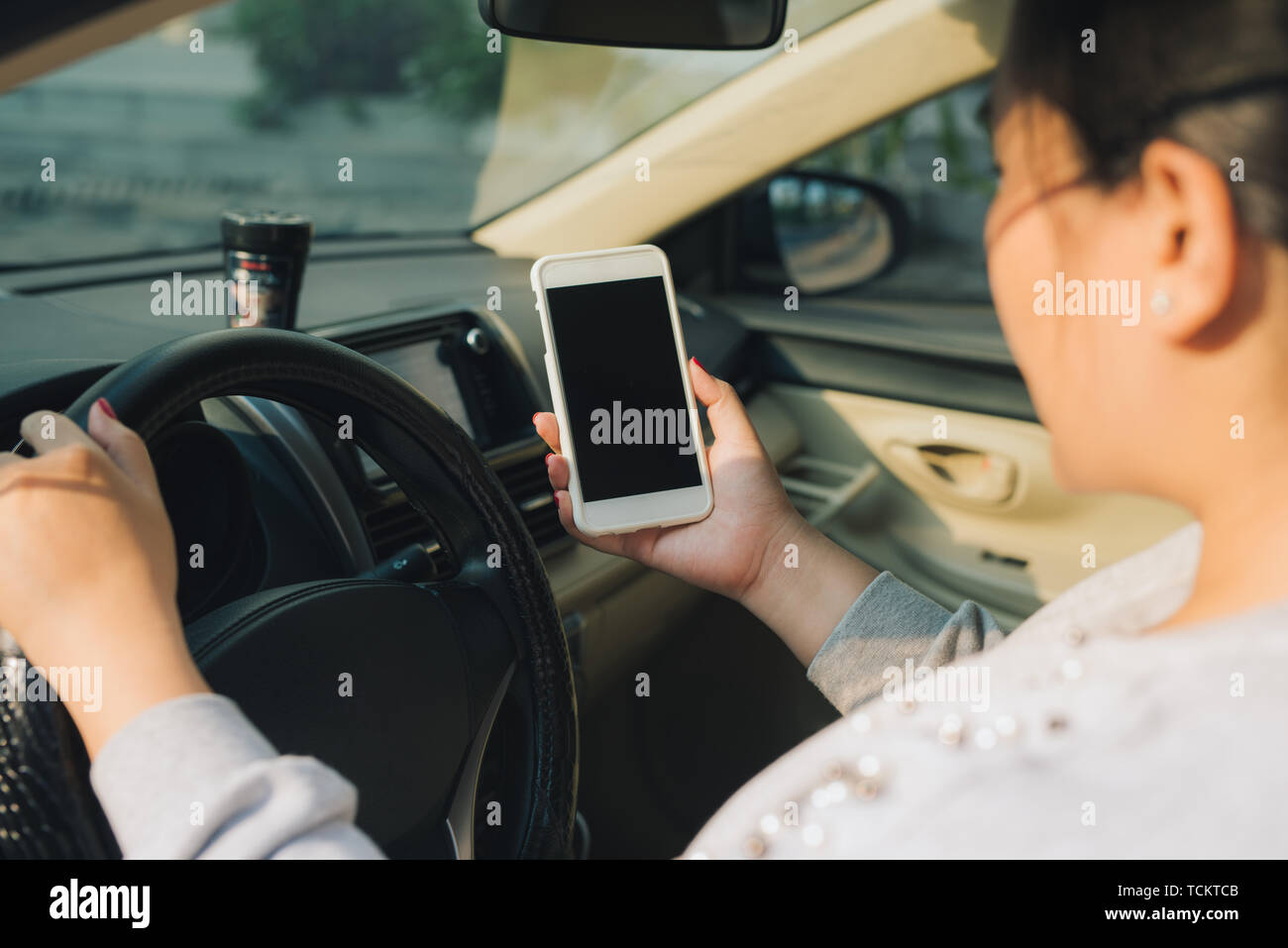 Mockup Bild der Frau Treiber Smartphone mit leerer Bildschirm in einem Auto. Stockfoto