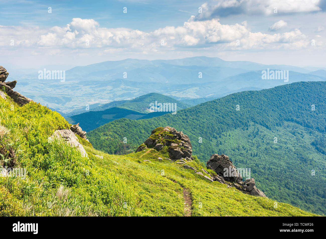 Tolle Aussicht von der Spitze eines Berges. Weg durch die Wiese mit riesigen Felsbrocken auf dem Rand. Sommer Landschaft mit Hügeln der Ridge Rolling down Stockfoto