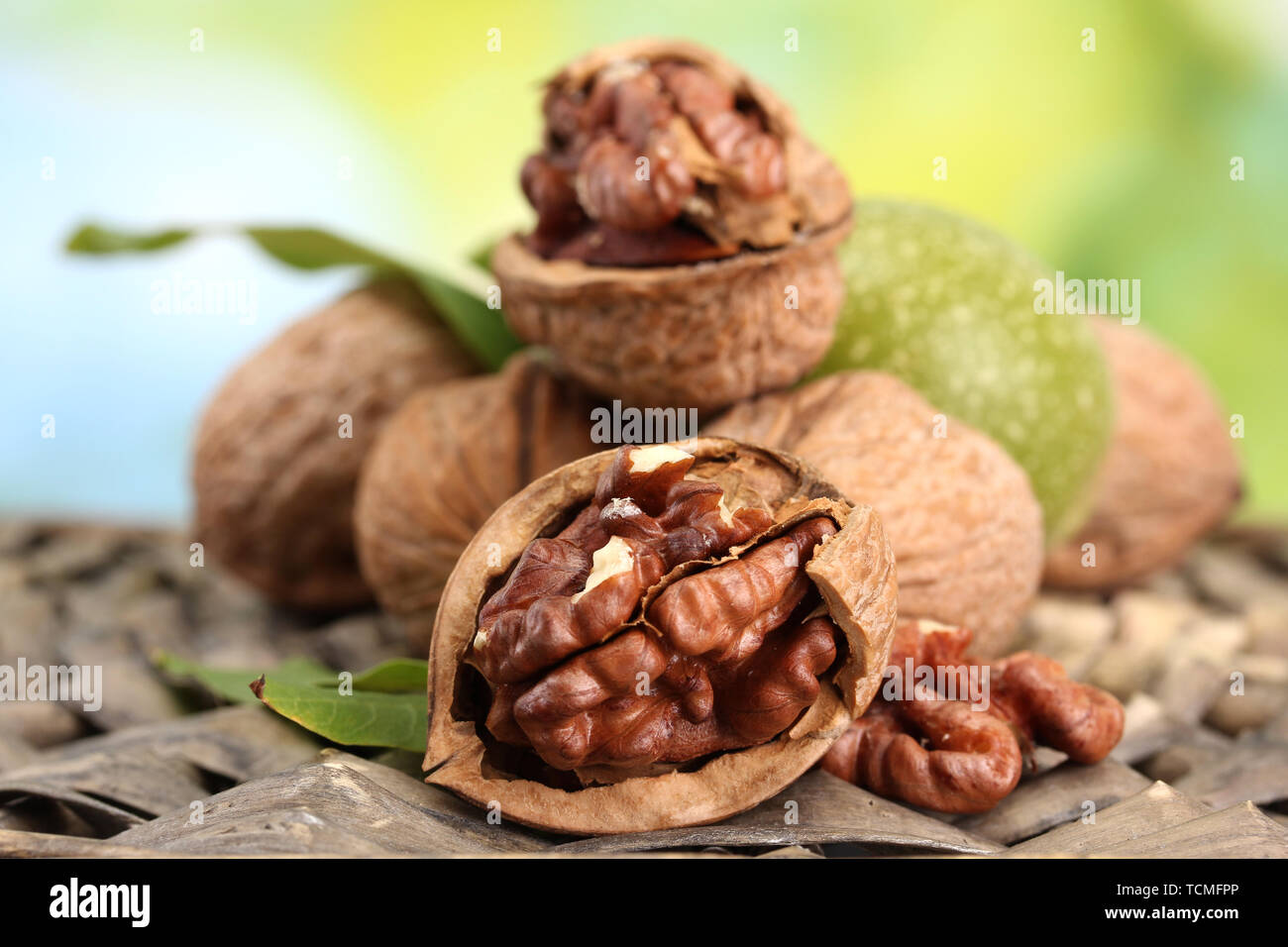 Walnüsse mit grünen Blättern in Garten, auf grünem Hintergrund Stockfoto