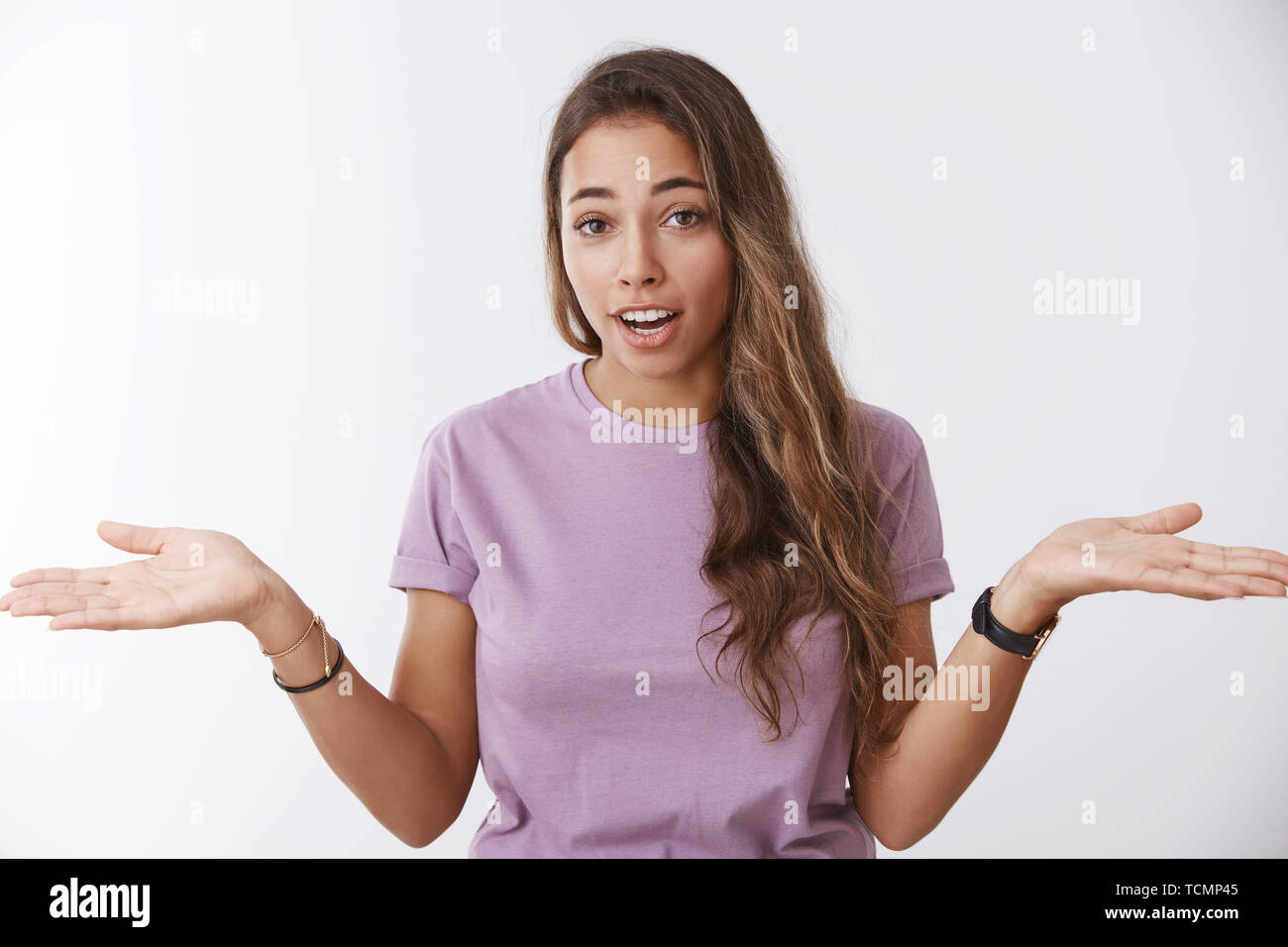 Gleichgültig sorglose Ruhe unbothered junge Frau zucken Verbreitung Hände seitlich ahnungslos hebt Augenbrauen Wiedergabe ohne Idee, ständigen ungewiss Stockfoto