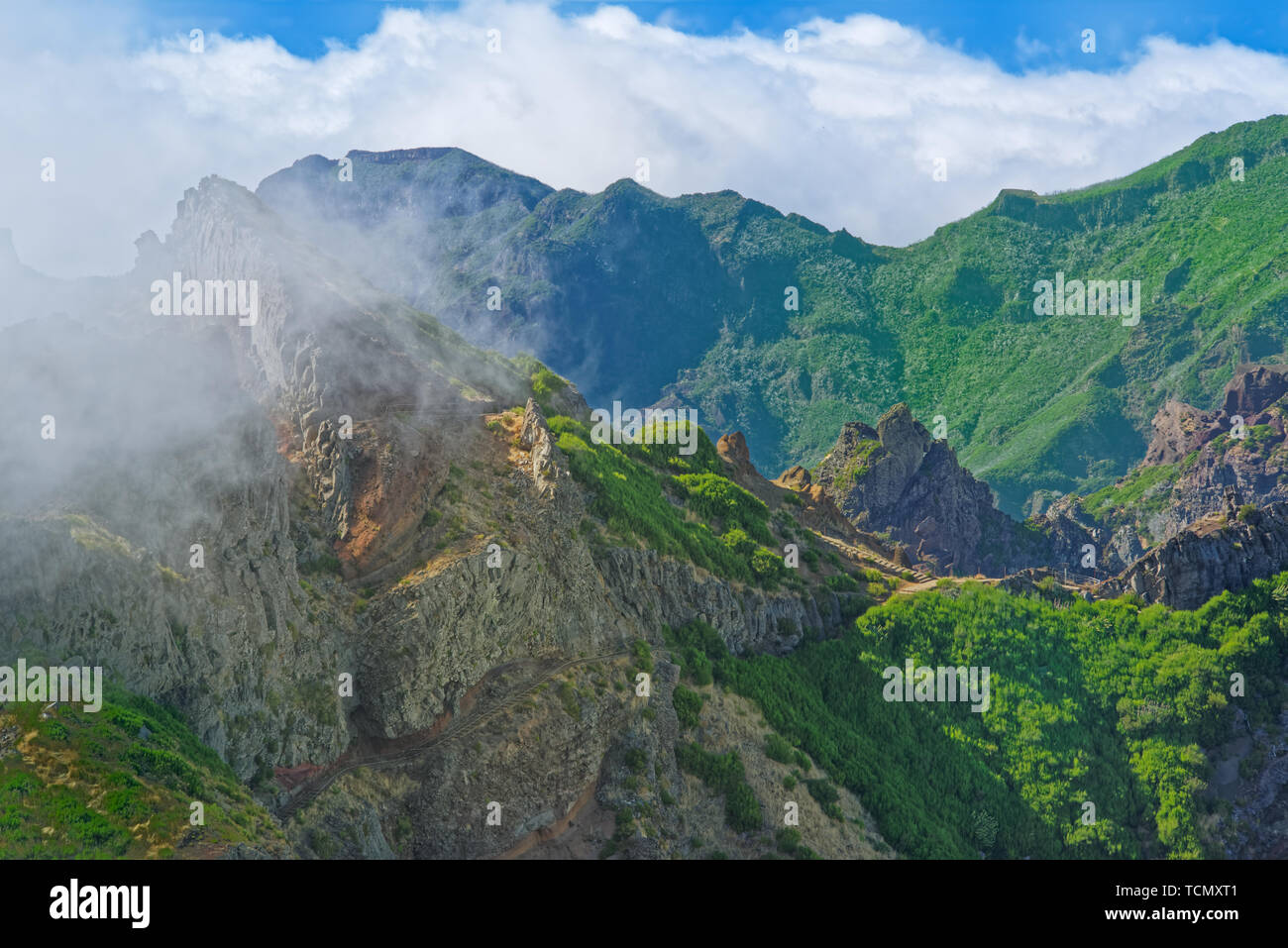 Natur Szene von grünen Bergen gegen bewölkt blauer Himmel. Blick vom Pico do Ariero auf der portugiesischen Insel Madeira Stockfoto