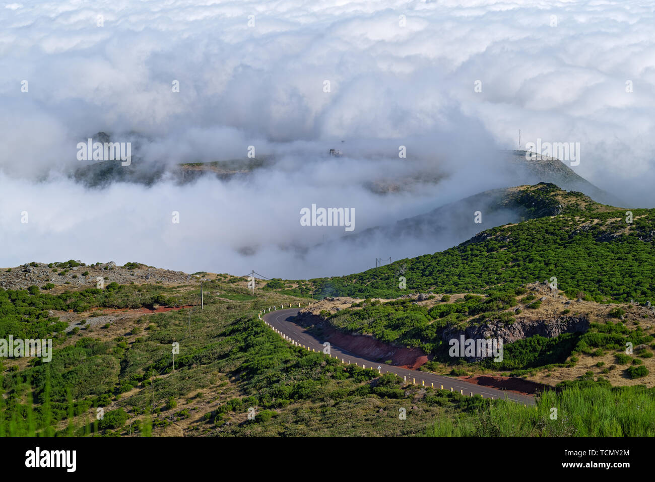 Leere Straße in der Landschaft gegen dichte Wolken. Blick vom Pico Do Arieiro auf der portugiesischen Insel Madeira Stockfoto