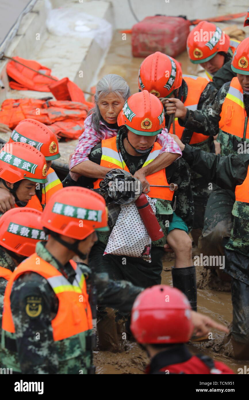 Guilin, China Guangxi Zhuang autonomen Region. 9. Juni, 2019. Retter Transfer eine gealterte Frau an Zhaojia Dorf Quanzhou County in Guilin im Süden Chinas Autonomen Region Guangxi Zhuang, 9. Juni 2019. Guangxi der meteorologischen Büro am Sonntag Abend aktualisiert die meteorologischen Disaster Emergency Response auf Stufe-II nach Unwetter ab Dienstag Überschwemmungen in mehreren Städten verursacht. Credit: Wang Zichuang/Xinhua/Alamy leben Nachrichten Stockfoto