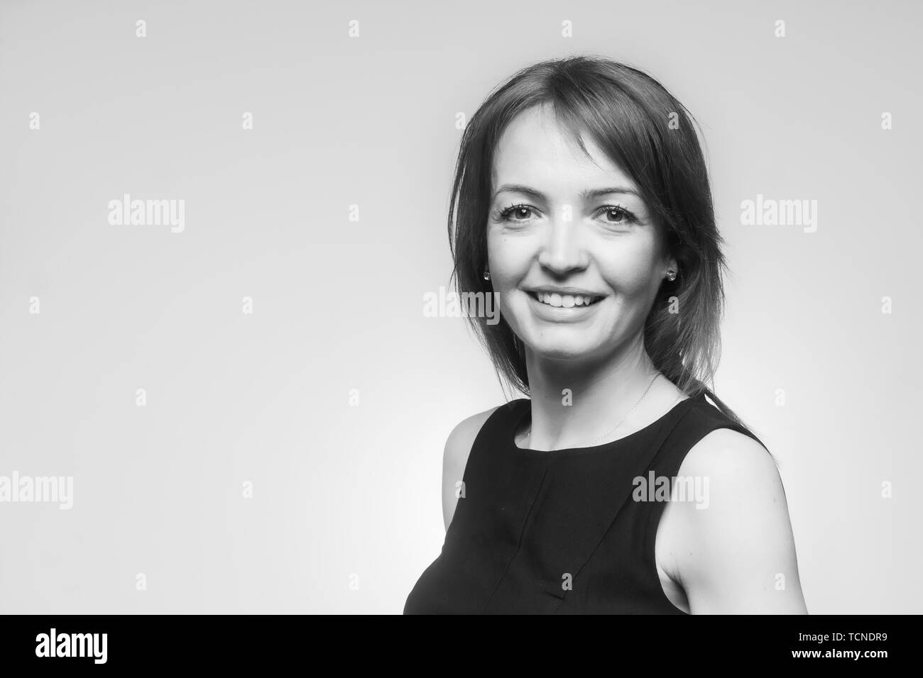 Ein Lächeln auf den Lippen reife Frau, 40-49 Jahre alt, gut aussehend und schöne Portrait. Mit Blick auf die Kamera. Obere Körper geschossen, trägt ein einfaches schwarzes Kleid. Schuss Stockfoto