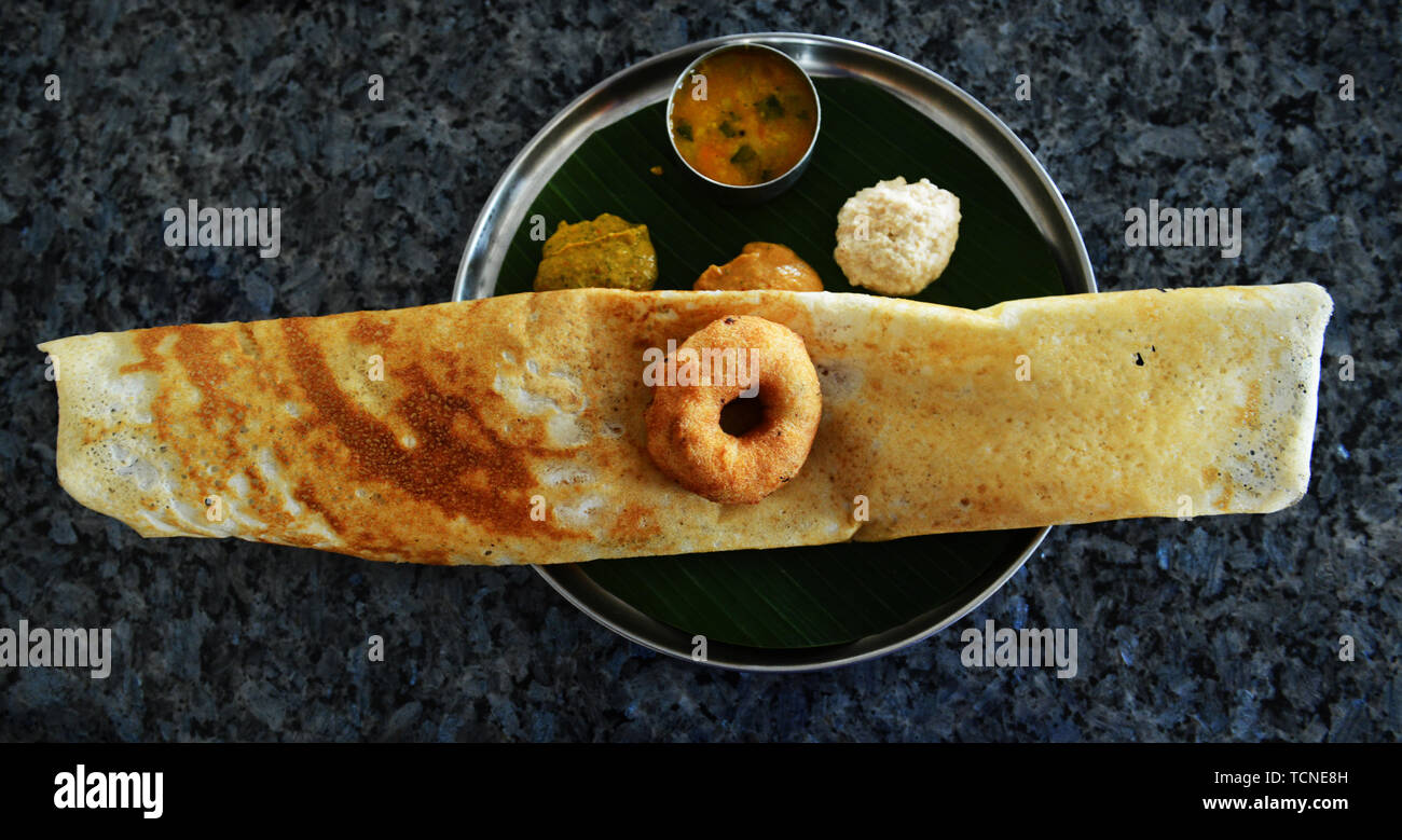 Masala Dosa serviert mit Medu Vada und verschiedene Chutneys. Stockfoto