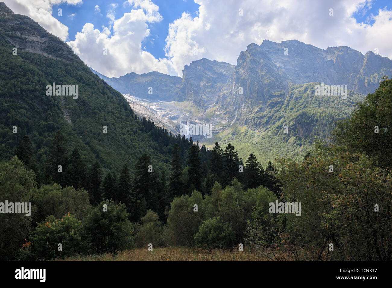 Panoramablick auf Berge Szene und weit entfernten Wasserfall im Nationalpark von Dombay, Kaukasus, Russland. Sommer Landschaft, Sonnenschein Wetter und sonnigen Tag Stockfoto