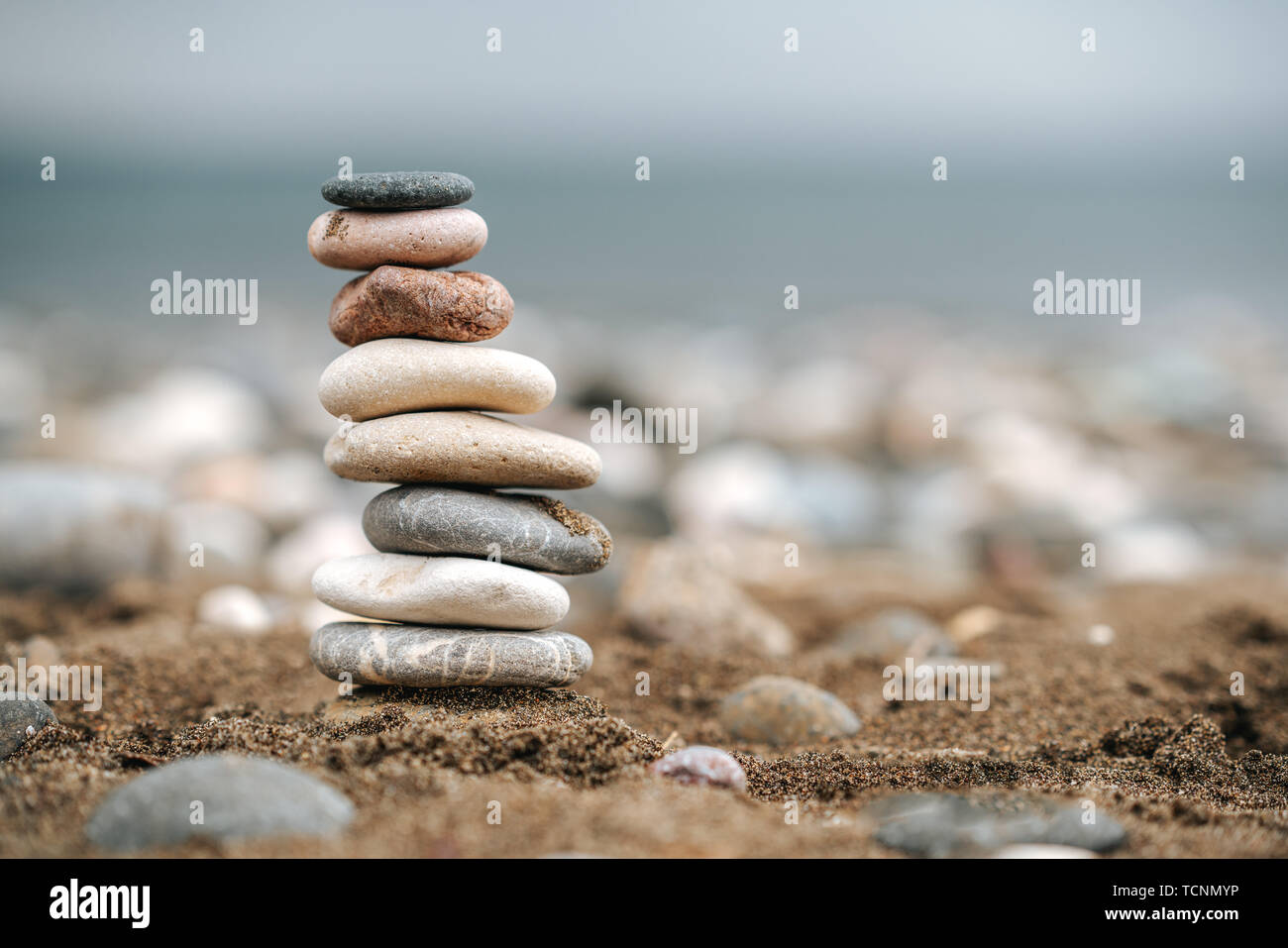 Stapel von Stein über den Sand. Balance und Stabilität Konzept mit Steinen Stockfoto