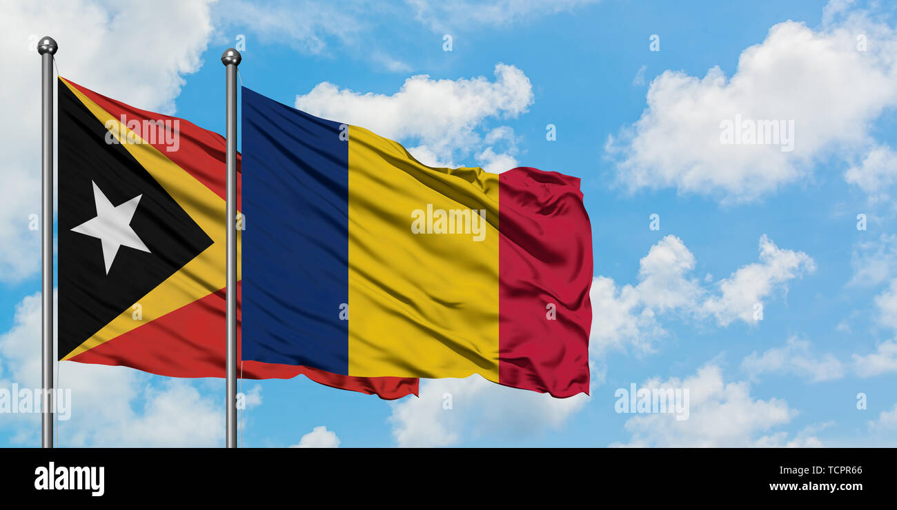 Osttimor und Tschad Fahne im Wind gegen Weiße bewölkt blauer Himmel zusammen. Diplomatie Konzept, internationale Beziehungen. Stockfoto