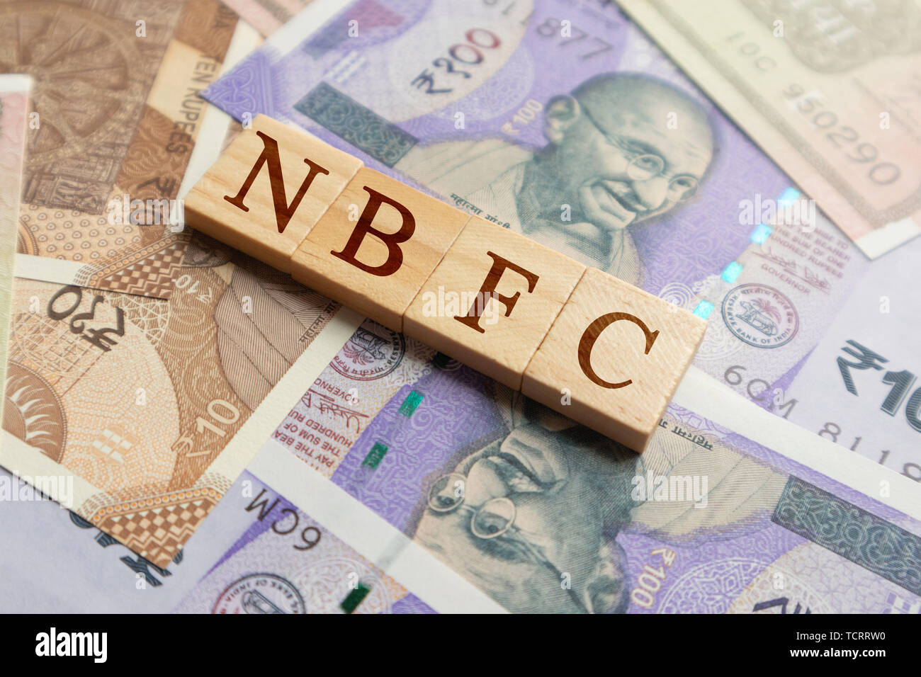 NBFC in Holzblock Buchstaben auf der indischen Währung. Stockfoto