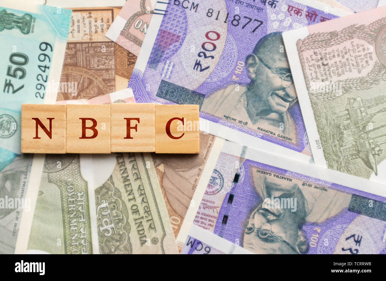 NBFC in Holzblock Buchstaben auf der indischen Währung Stockfoto