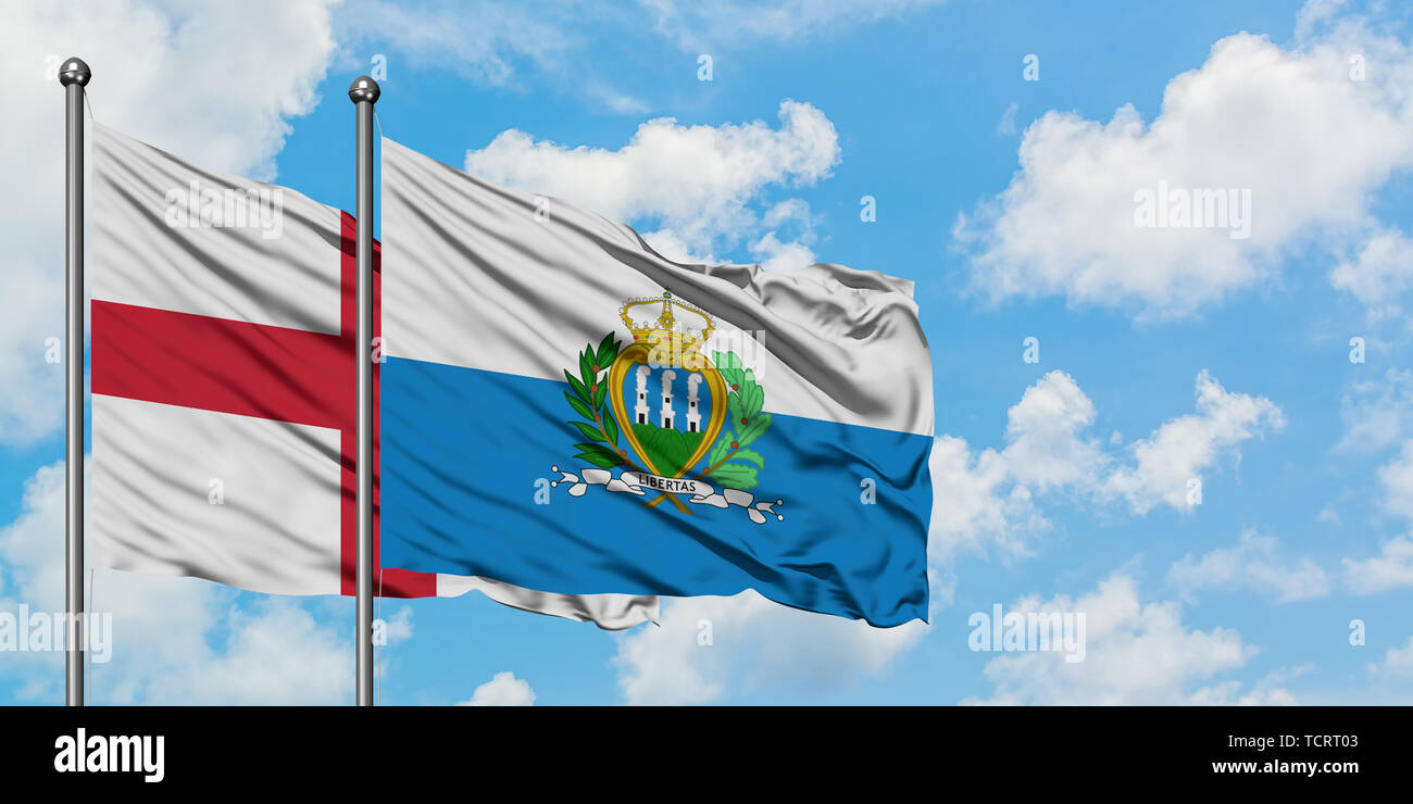 England und San Marino Fahne im Wind gegen Weiße bewölkt blauer Himmel zusammen. Diplomatie Konzept, internationale Beziehungen. Stockfoto