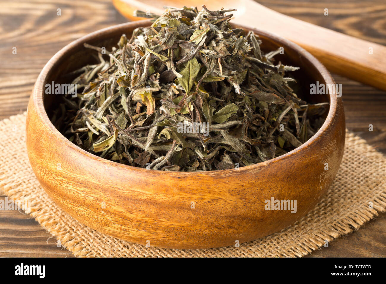 Haufen von getrockneten Rohstoffen, weisser Tee Blätter in Houten auf Bambus matte Hintergrund Stockfoto