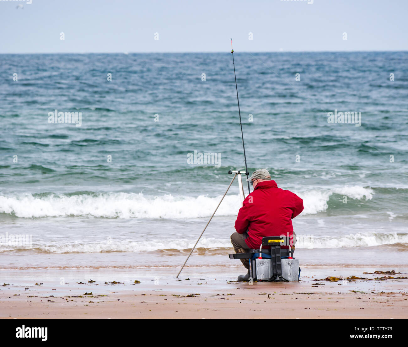 Tyninghame Strand, East Lothian, Schottland, Vereinigtes Königreich, 10. Juni 2019. UK Wetter: ein älterer Mann Meer angeln mit Angel am Rand von einem Sandstrand an der Nordsee suchen Stockfoto