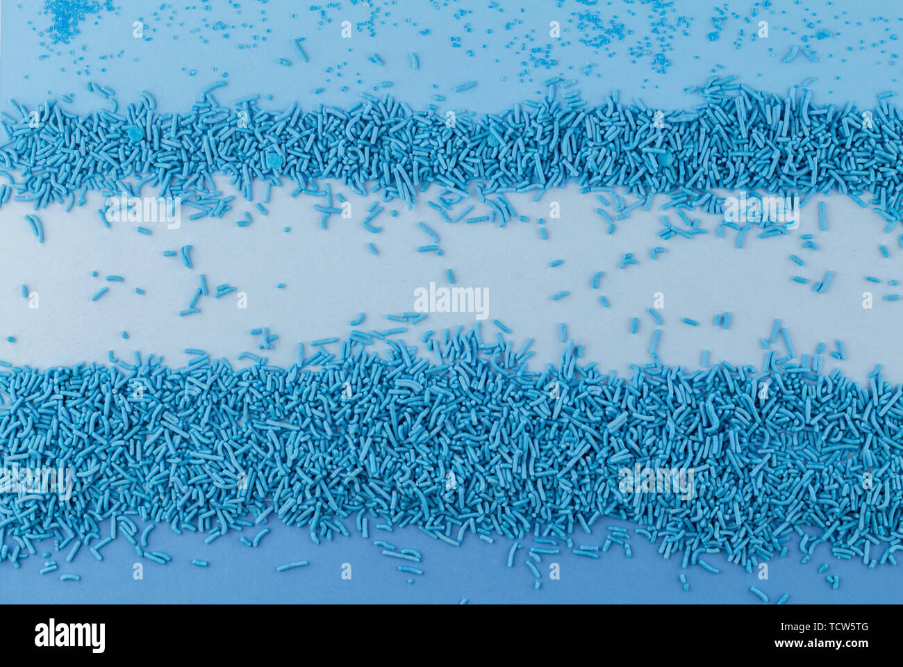Streuen Sie Hintergrund mit blauer Kuchen topping besprüht und Zucker Kristalle - Ansicht von oben mit Text Raum Stockfoto