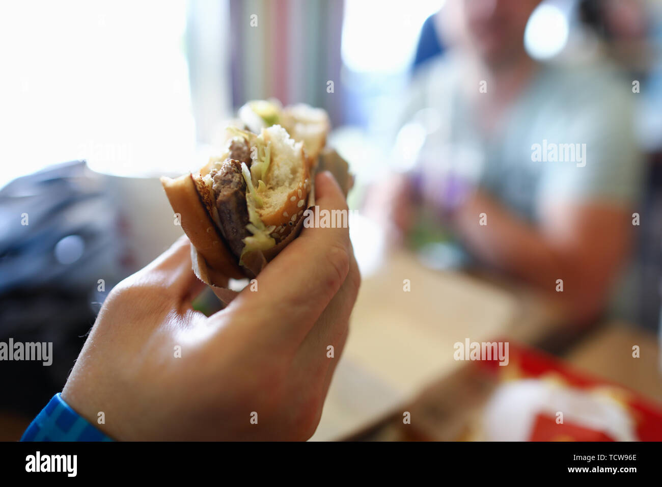 Männliche hand Halten teasty Burger in der Hand Ggeen Stockfoto