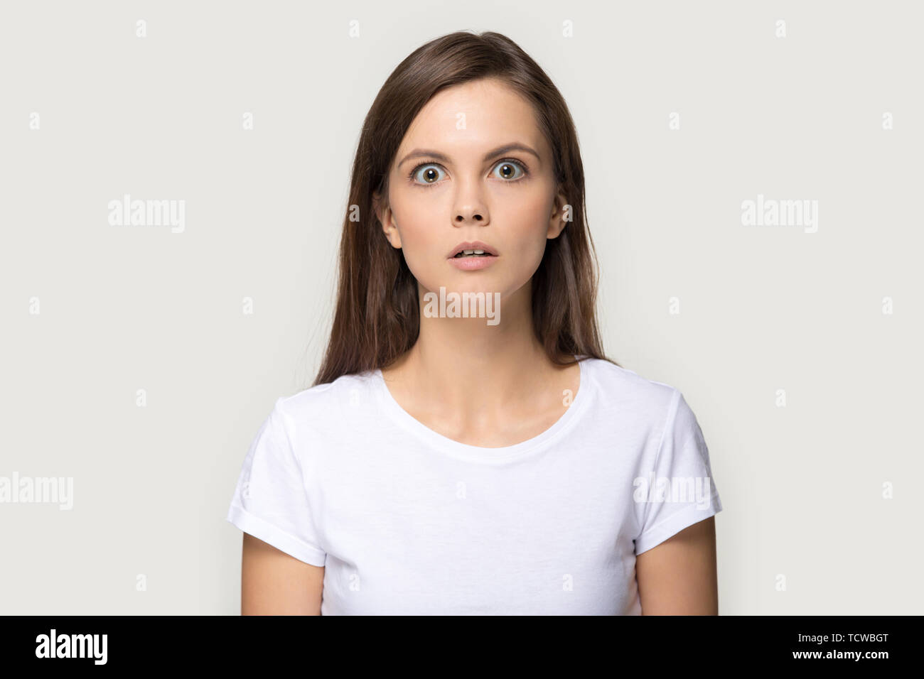 Angst Mädchen auf Kamera über Grau studio Hintergrund posiert Stockfoto