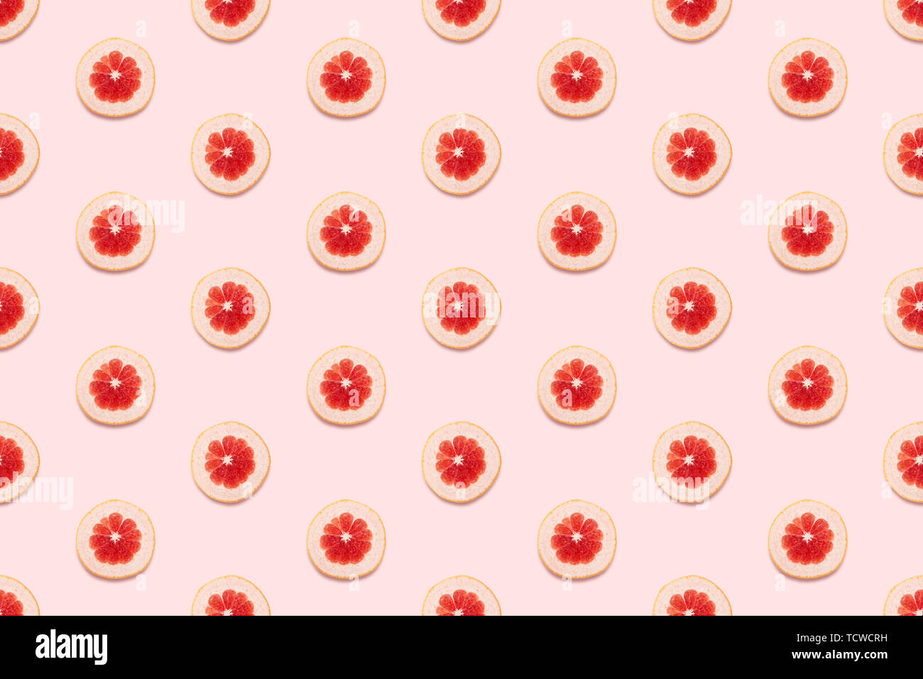 Pampelmusen Scheiben nahtlose Muster auf Pastell rosa Hintergrund. Minimale Sommer Konzept. Flach, trendige saftige Farbe. Stockfoto