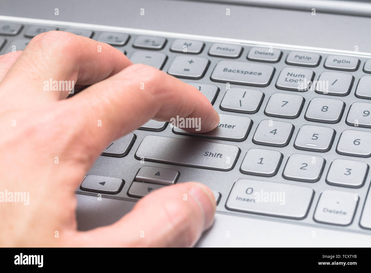 Close-up Finger auf die RETURN-Taste der Tastatur gedrückt. Stockfoto