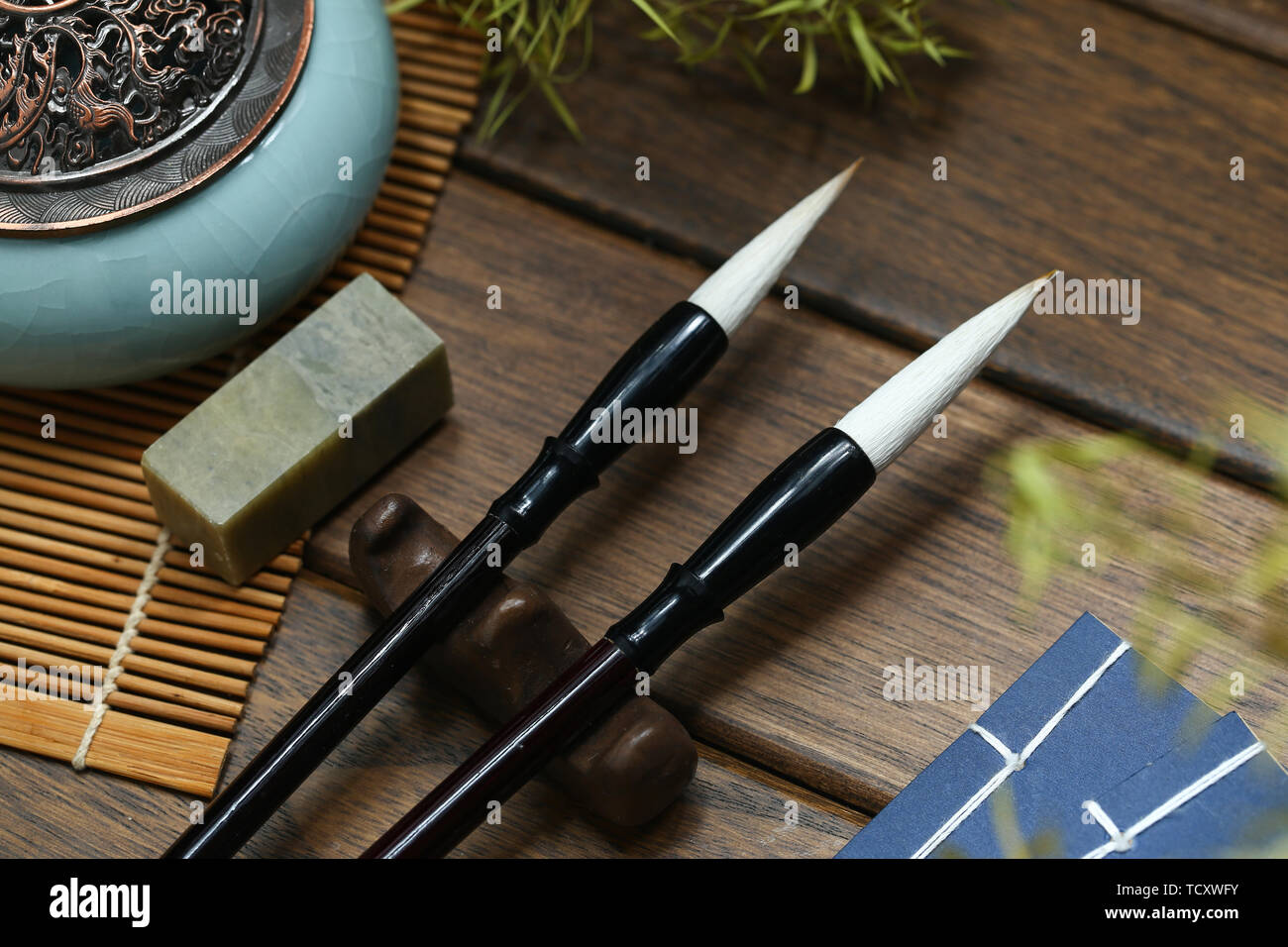 Chinesische Schrift Bürsten, Vintage altes Buch, Räuchergefäß auf hölzernen Tisch Stockfoto