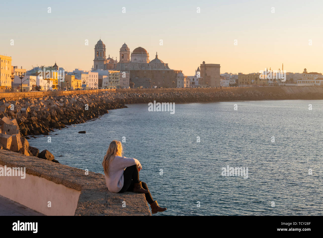 Frau genießen den Blick auf die Kathedrale von Santa Cruz und das Meer von der Promenade entlang Kai, Cadiz, Andalusien, Spanien, Europa Stockfoto