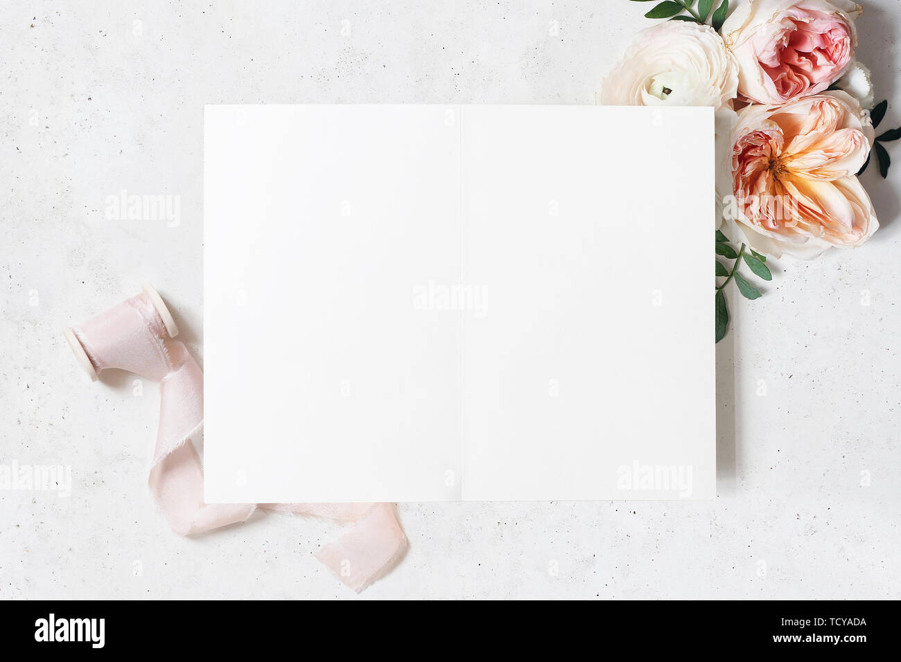 Hochzeit, Geburtstag Schreibwaren Mock-up-Szene. Leere offene gefaltete Grußkarte. Die dekorativen Blumenmotiv. Grüne Blätter, Blush Pink Englische Rosen und Stockfoto