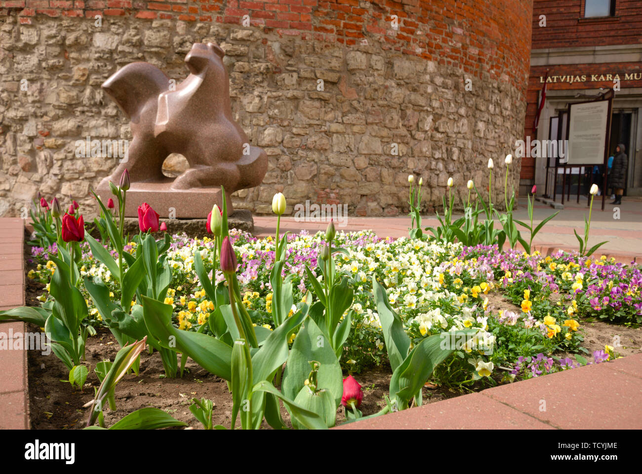 Statue und Blumenbeet im Lettischen Kriegsmuseum in Riga, Lettland Stockfoto