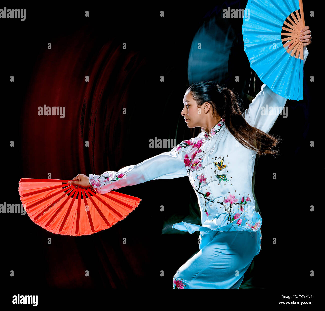Eine chinesische Frau partacticing Tai Chi Chuan Tadjiquan Körperhaltung studio Schuß auf schwarzen Hintergrund mit Licht malen Effekt isoliert Stockfoto