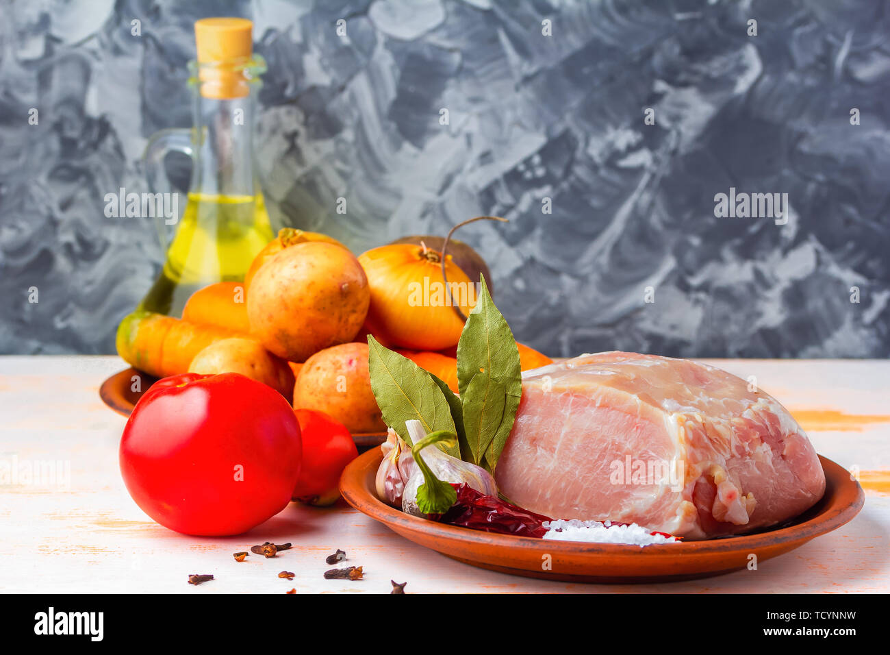 Rohes Schweinefleisch Filet, bratfertig, mit Gewürzen, schwarzer Pfeffer, Olivenöl, Knoblauch, Lorbeer, Salz Stockfoto
