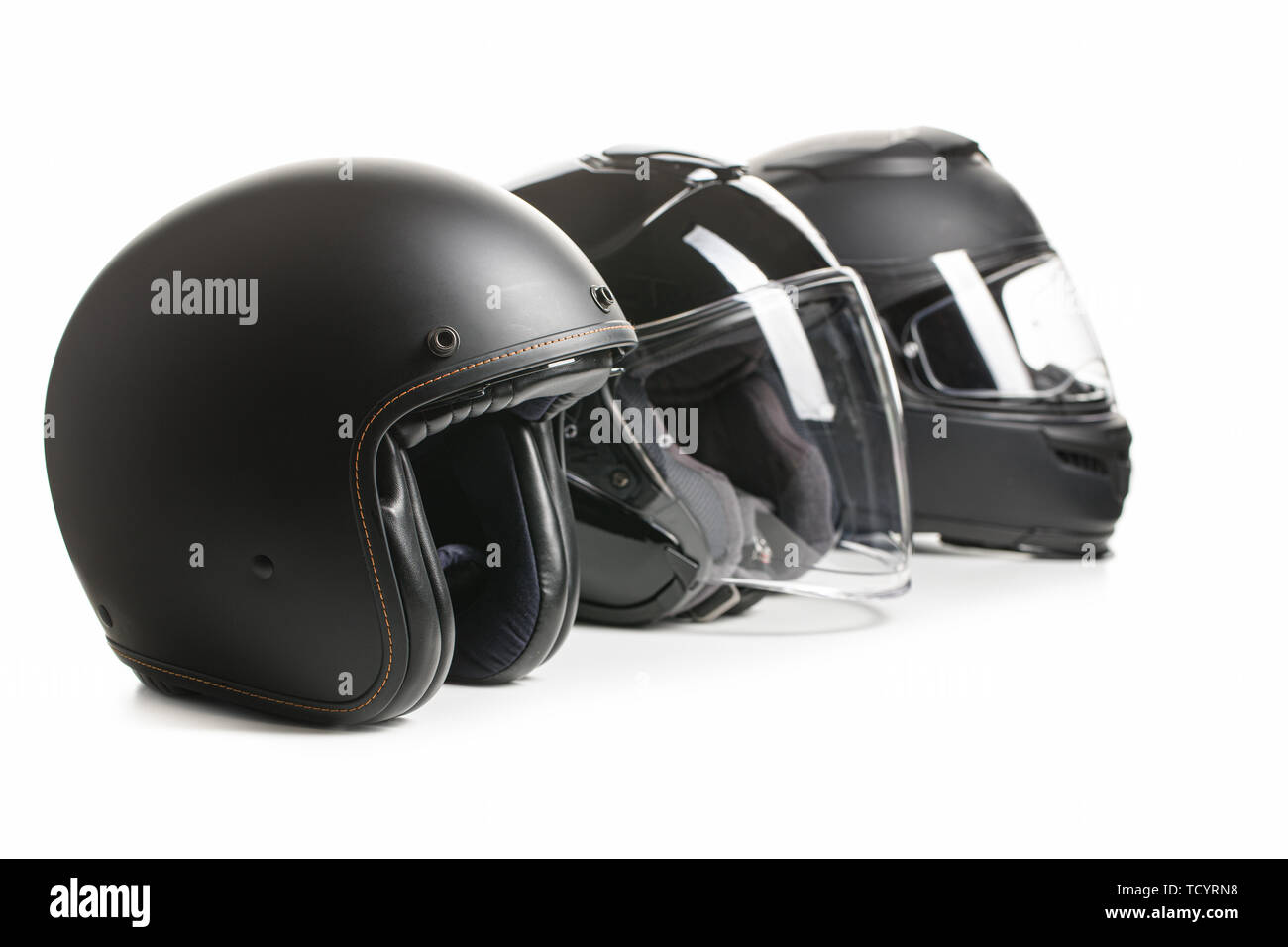 Drei schwarze Motorrad Helme isoliert auf weißem Hintergrund. Stockfoto