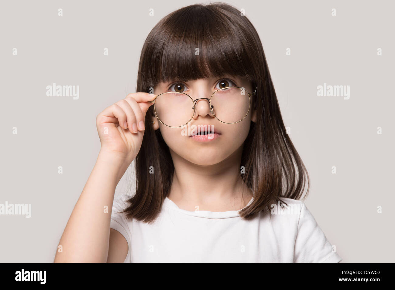 Lustige kleine Mädchen senken Brille mit Kamera fühlen Staunen Stockfoto