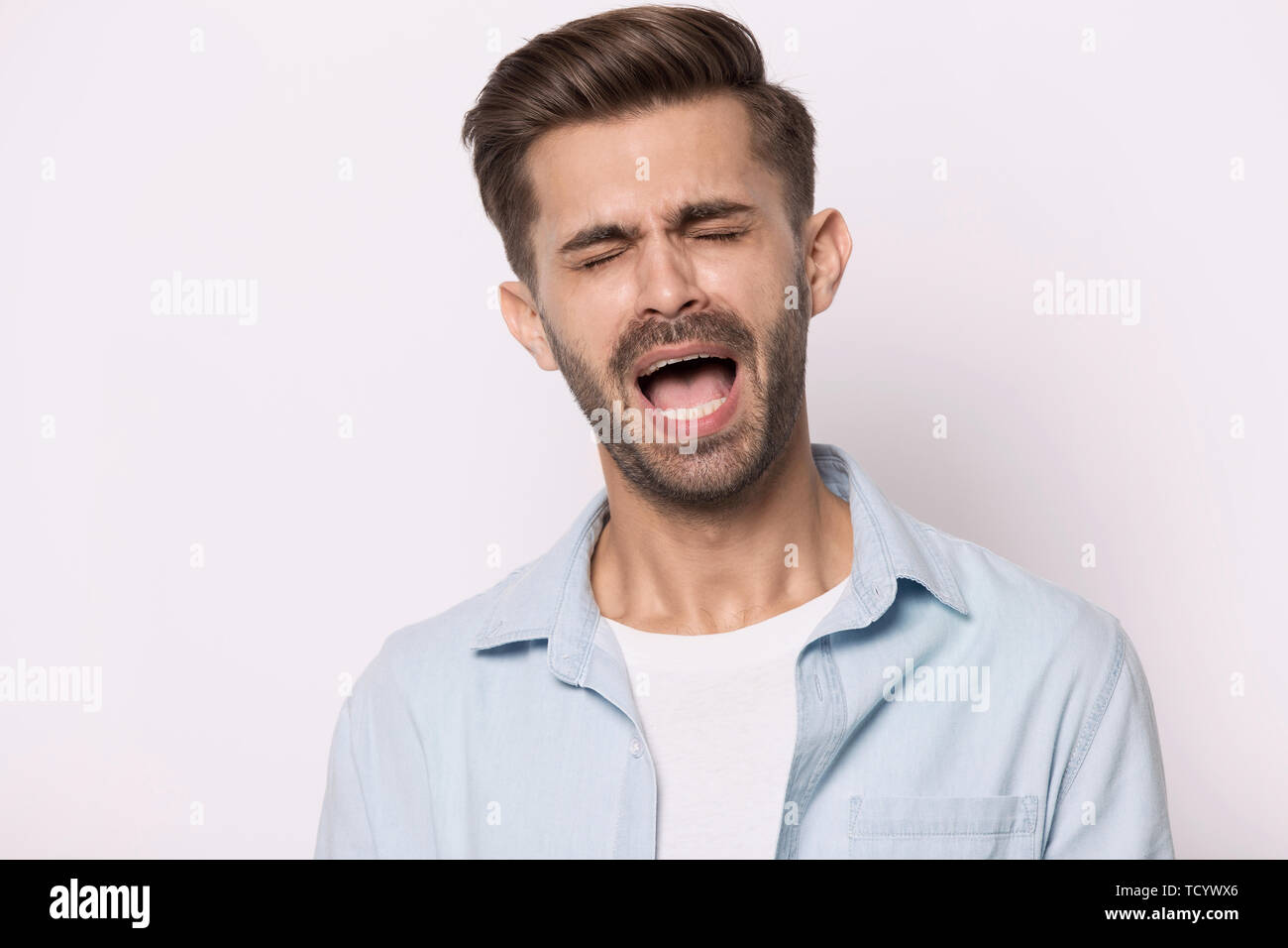 Hysterische Kerl geschlossenen Augen schreien oder jammert, isoliert auf weißem Stockfoto