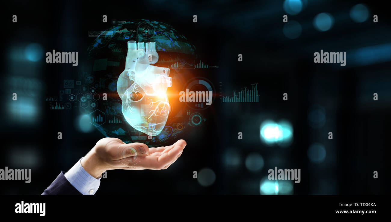 Der Mann die Hände auf Laptop und anatomische Herz Modell. Mixed Media. Stockfoto