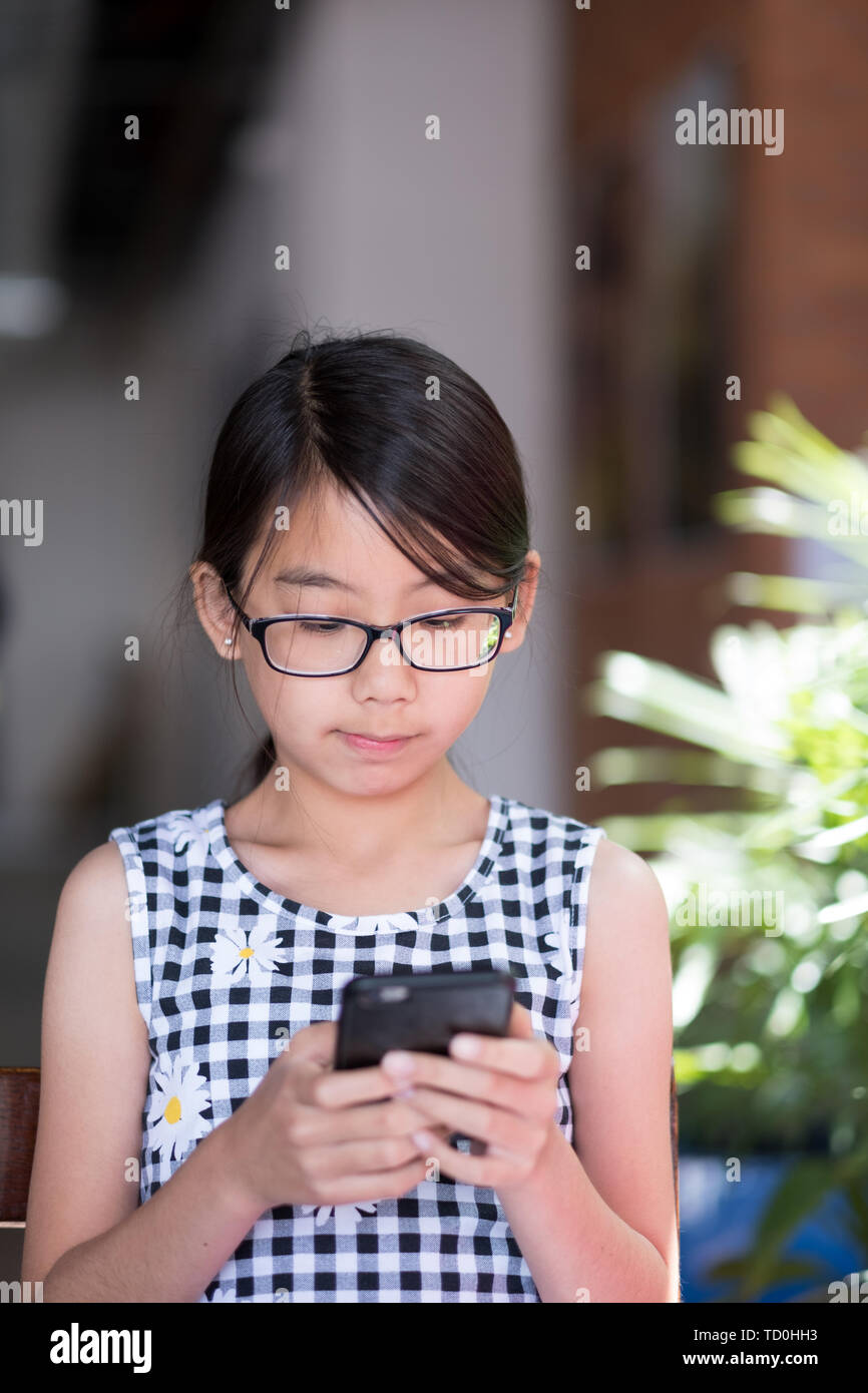 Ein jugendlich Mädchen mit Smart Phone im Cafe Stockfoto