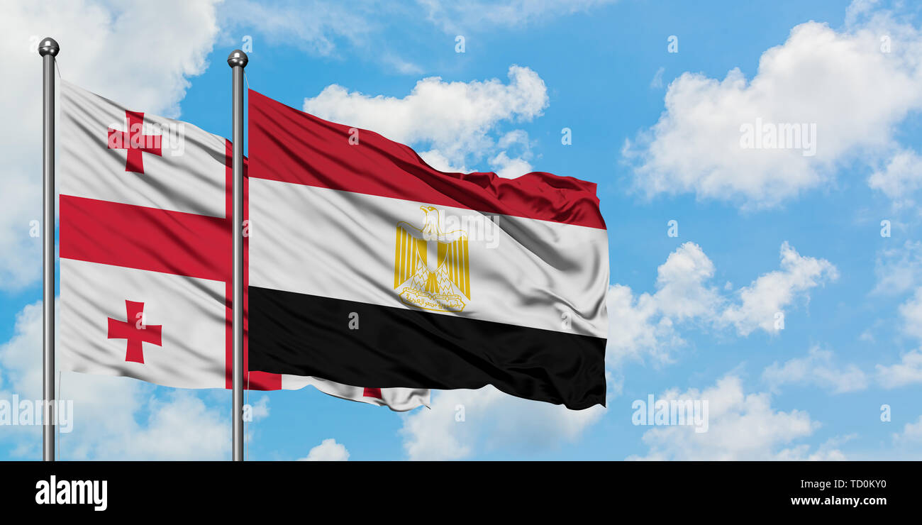 Georgien und Ägypten Flagge im Wind gegen Weiße bewölkt blauer Himmel zusammen. Diplomatie Konzept, internationale Beziehungen. Stockfoto