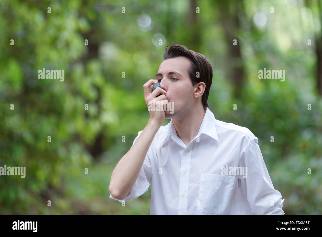 Junge Mann ist mit einem Asthma Inhalator Stockfoto