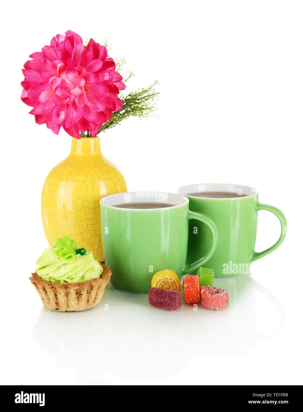 Tassen Tee mit Süßigkeiten, Kuchen und Blumen isoliert auf weißem Stockfoto