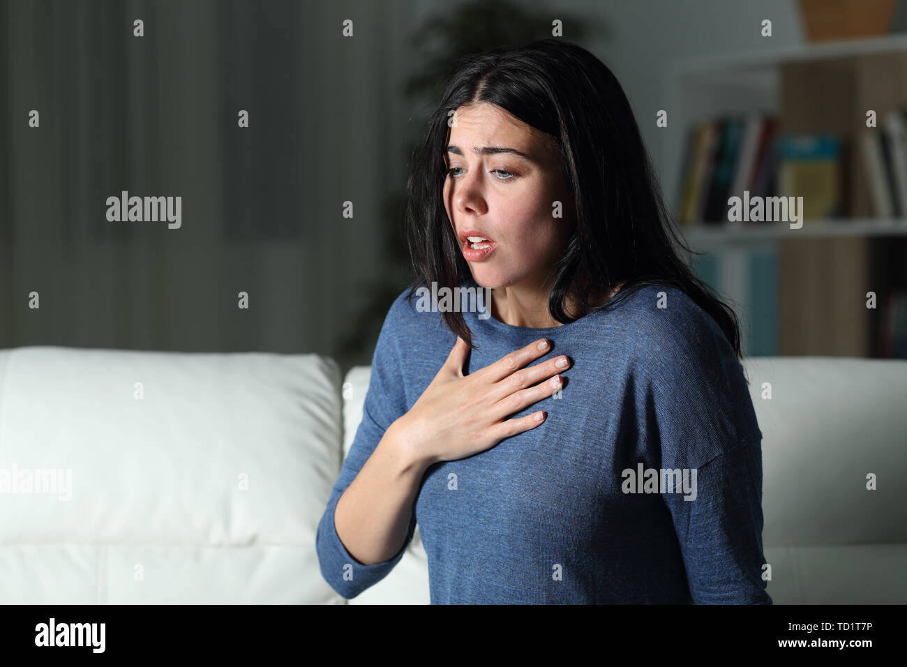 Frau mit einer Angst Angriff allein in der Nacht auf einer Couch zu Hause Stockfoto