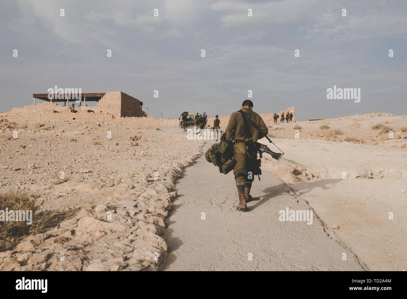 Zurück von einem Soldaten der israelischen Armee mit Requisiten an militärischen Übungen in den Ruinen der Festung Massada, Israel. Junge Soldaten zu Fuß Stockfoto