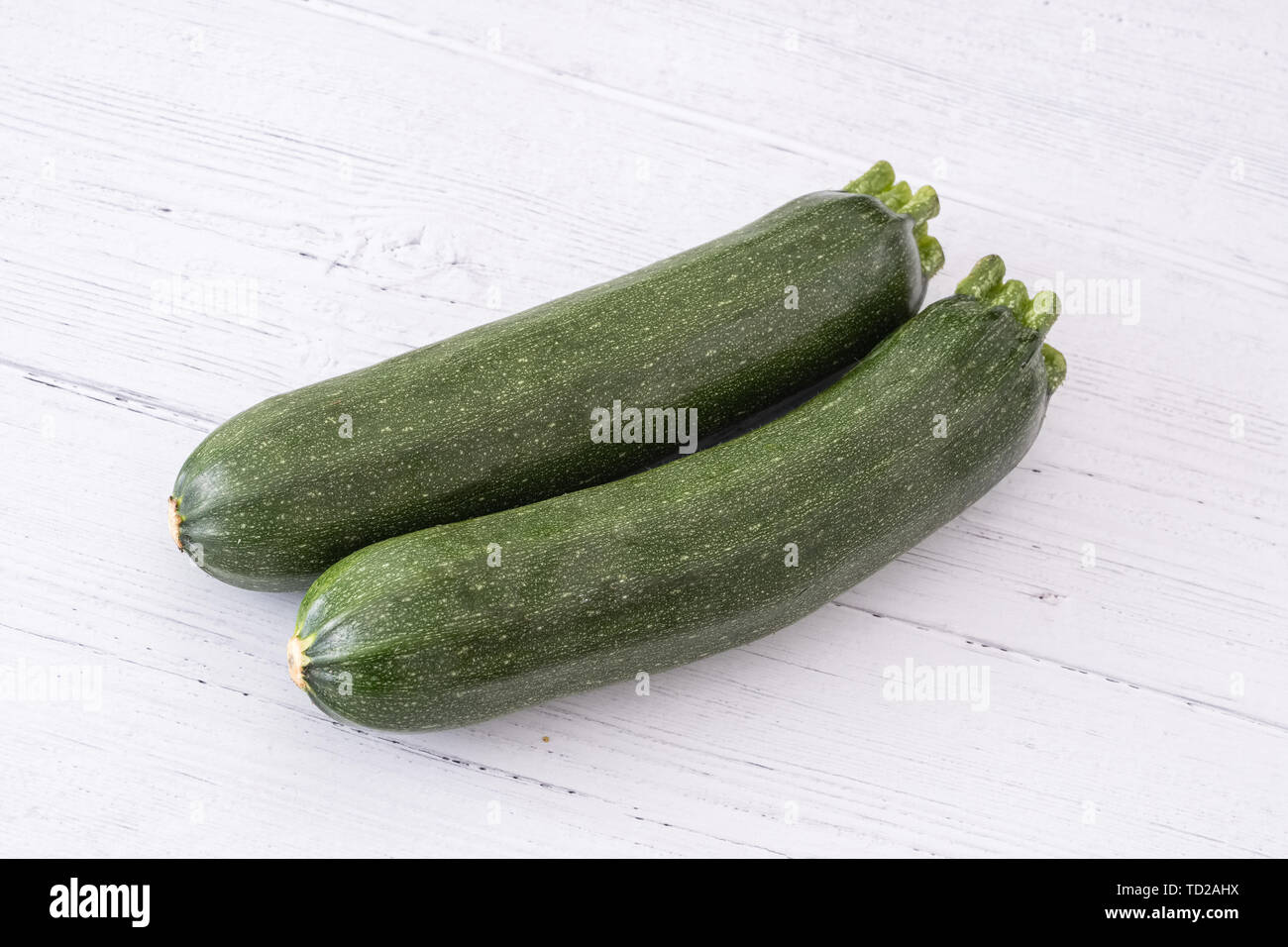 Schottische Zucchini stellten sich in einer Reihe auf einem weißen beplankten Holzbrett eine Ihrer "5 am Tag" für gesunde Ernährung. Stockfoto