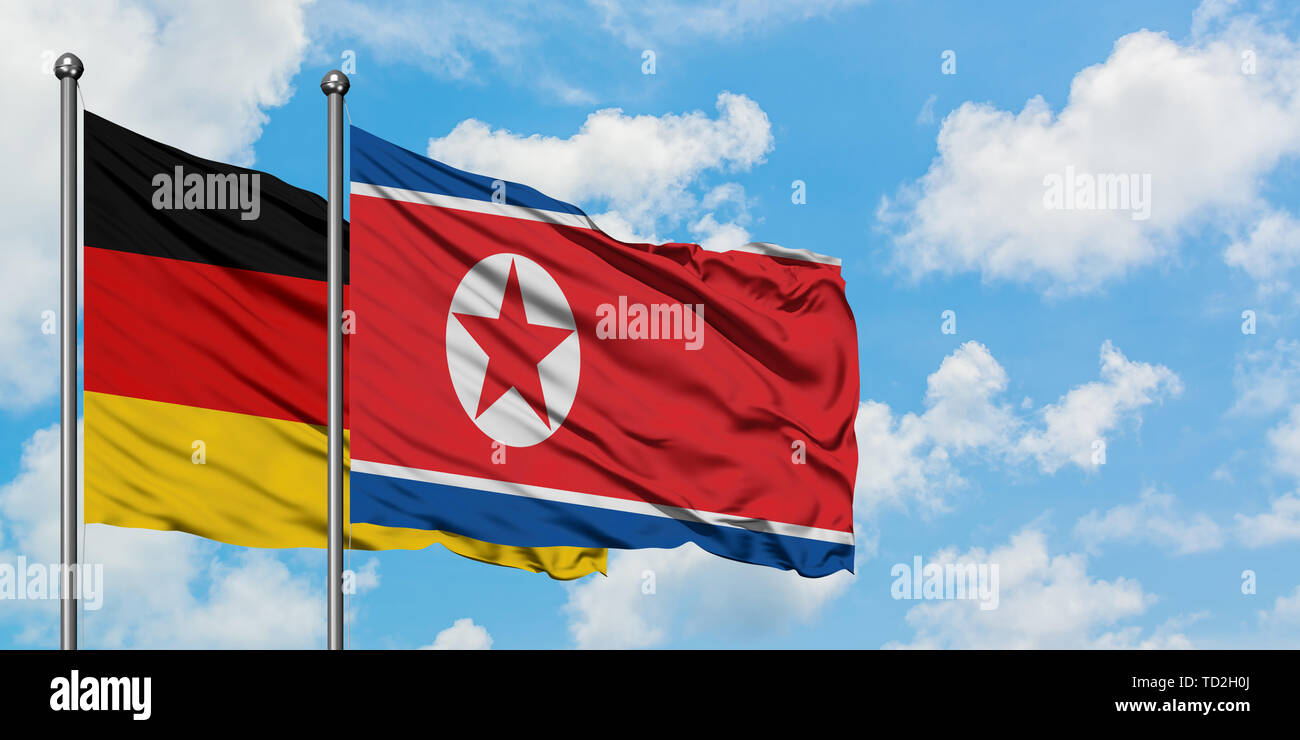Deutschland und Nordkorea Fahne im Wind gegen Weiße bewölkt blauer Himmel zusammen. Diplomatie Konzept, internationale Beziehungen. Stockfoto