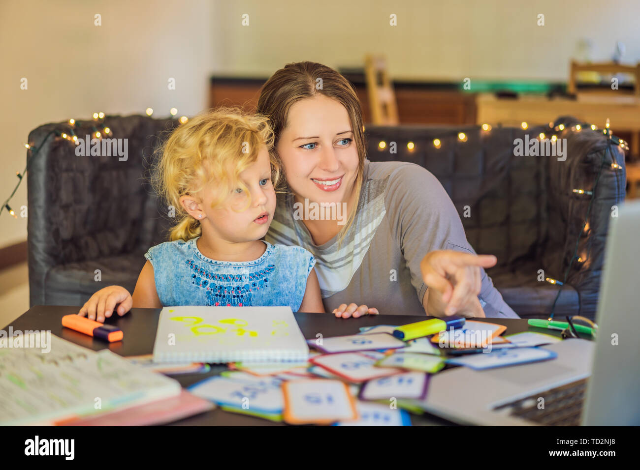 Ein Lehrer, ein Tutor für heimunterricht und ein Lehrer am Tisch. Oder Mutter und Tochter. Homeschooling Stockfoto